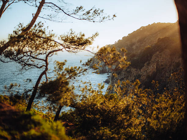 Golden sunrise above the Mediterranean Sea with historic medieval walls of Tossa de Mar, Costa Brava, Catalonia, Spain, popular holiday and photography location.