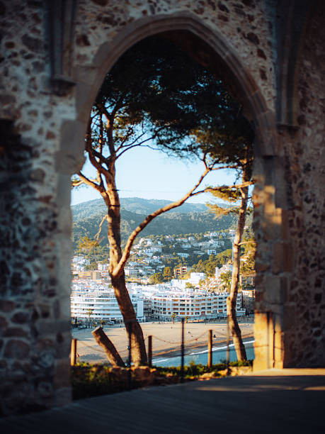 Golden sunrise above the Mediterranean Sea with historic medieval walls of Tossa de Mar, Costa Brava, Catalonia, Spain, popular holiday and photography location.