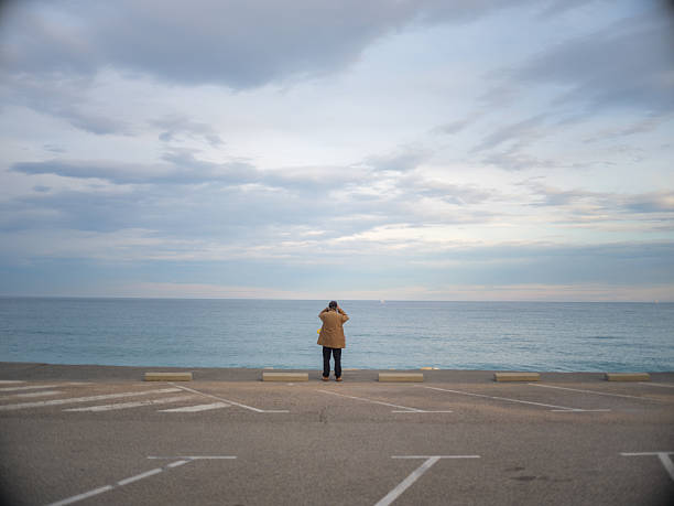 Silhouette of a photographer taking photos at sunset by the sea. Lifestyle