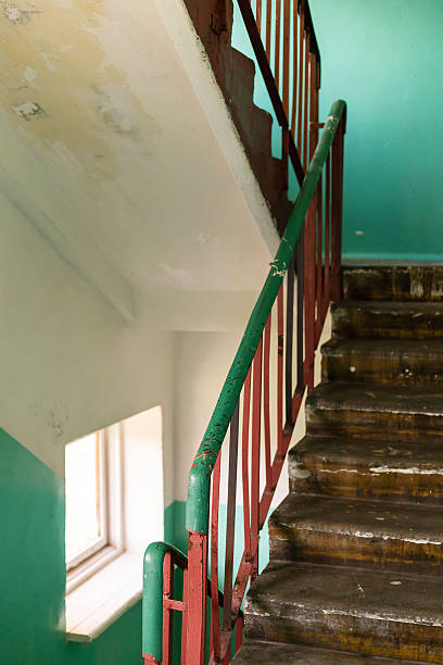 istock This location features a stairway within an old building showing signs of decay, including peeling paint and damaged wooden steps. The green walls add a contrasting touch to the neglect 2233475499