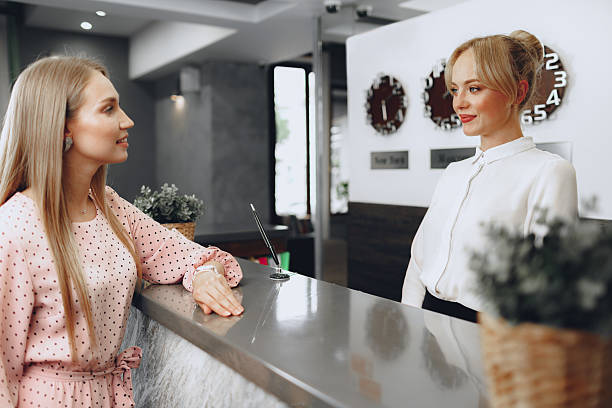 istock Blonde woman hotel guest checking-in at front desk in hotel 2233475708