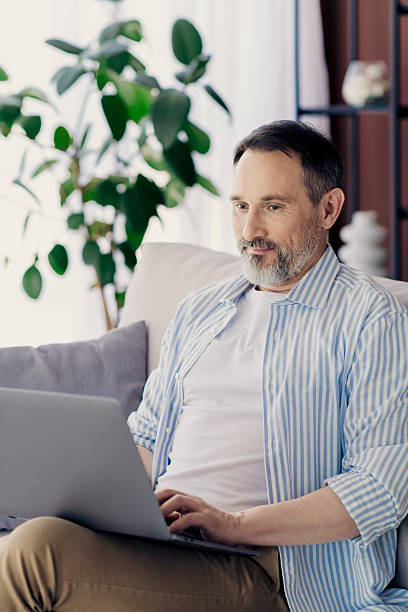 istock Mature professional working on laptop in a relaxed modern home environment showcasing confidence and productivity 2233477519