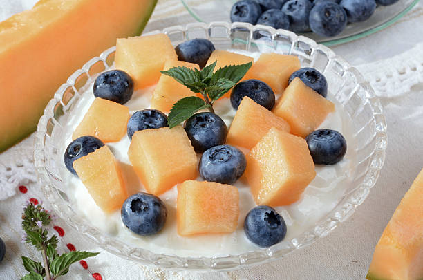 Pieces of melon and grapes on a white plate. Juicy fruits.
