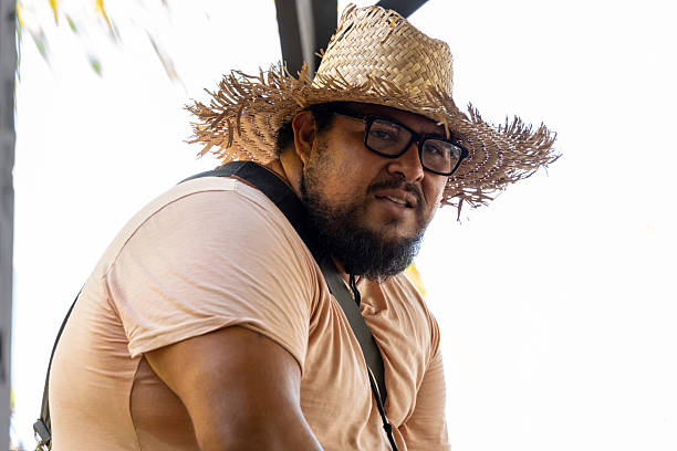 Latino man relaxing with a straw hat and sunglasses on a tropical beach in Cahuita, Costa Rica