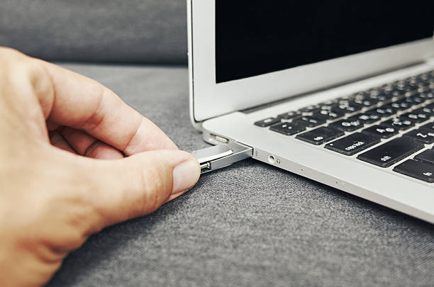 istock Person is plugging in a USB drive into a laptop 2233478991