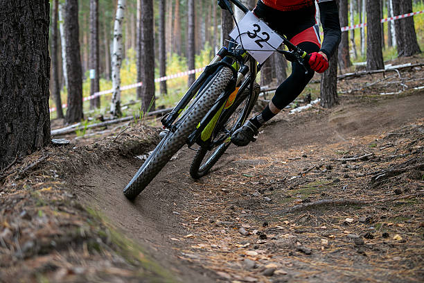 istock Athlete cyclist riding on sharp turn forest trail in mountain bike race 2233480229