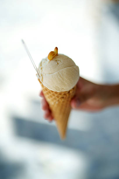 Hand Holding a Waffle Cone with Vanilla Ice Cream