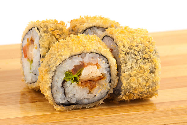 istock Deliciously Crispy Fried Sushi Rolls Served on a Wooden Platter 2233483970