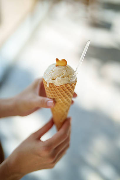 Hand Holding a Waffle Cone with Vanilla Ice Cream