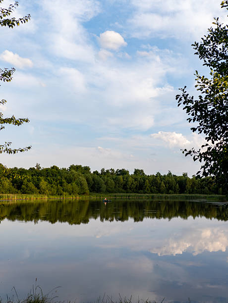 istock A person in a canoe on a lake surrounded by trees 2233485453