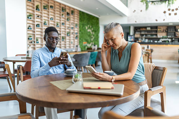 istock Business colleagues using smartphones during coffee break 2233485889