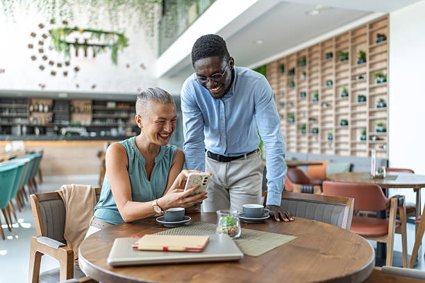 istock Business colleagues sharing a laugh while looking at smartphone in cafe 2233485899