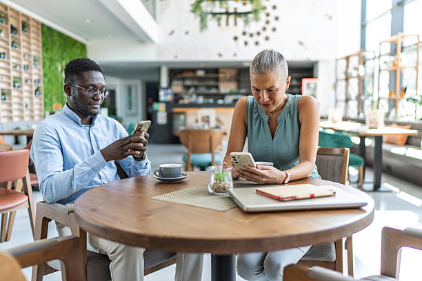 istock Business colleagues using smart phones in cafe 2233485920