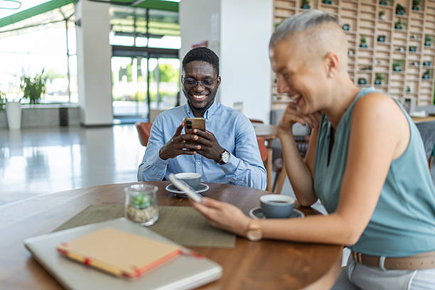 istock Business colleagues sharing funny content on smartphone during coffee break 2233485924