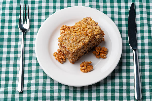 Piece of nut cake on white plate, close up