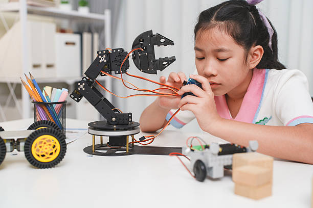 istock Dedicated schoolgirl, observing the prototype of robotic car, she testing 2233488490