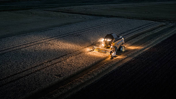 istock Combine harvesting wheat at night, aerial view 2233490460