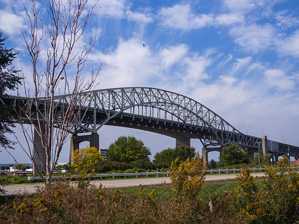 istock Steel Arch Bridge Over Greenery Under a Clear Blue Sky 2233494346