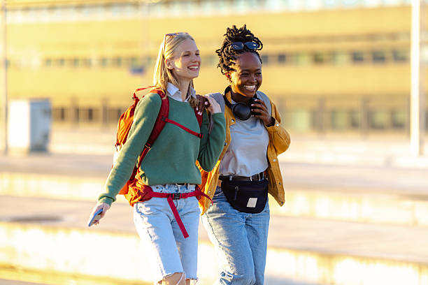 istock Two female tourists with backpacks on a train station 2233495487