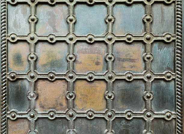istock Old bronze gates with ornament, rivets, and grille. Background 2233497421