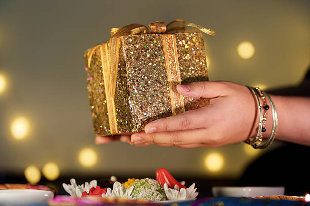 istock Diwali celebration. Hand holding a sparkling gift box during festive preparations. 2233498849