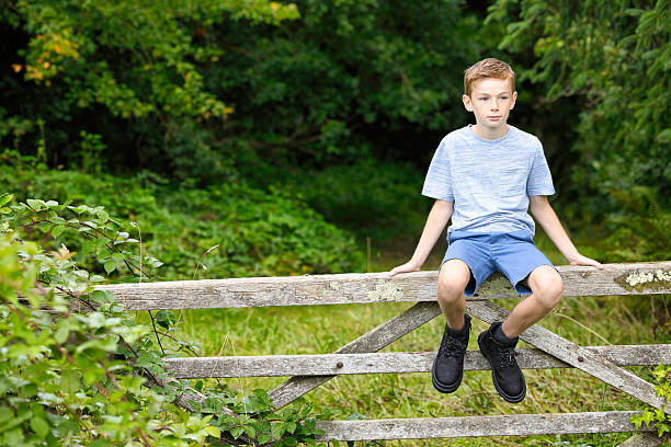 istock Boy of 10 sitting on a farm gate 2233499790