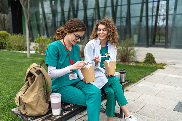 istock Two young doctors enjoying lunch break outdoors 2233500352