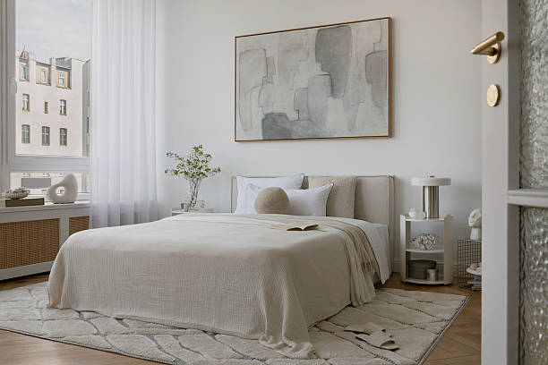istock Stylish compositions of bedroom with soft lighting, layered textiles, decorations and abstract wall art. Neutral tones and quiet elegance. 2233500601