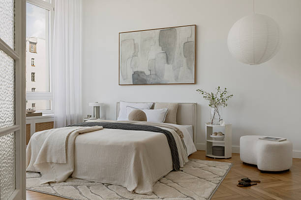 istock Minimalist bedroom with abstract mock up artwork, neutral bedding, and layered textiles in soft daylight. Stylish home decor. 2233500605