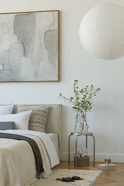 istock Stylish compositions of bedroom with soft lighting, layered textiles, decorations and abstract wall art. Neutral tones and quiet elegance. 2233500631