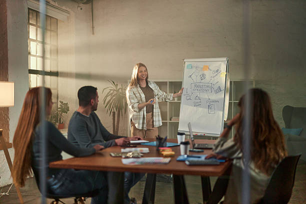 istock Happy freelancer giving a presentation to her colleagues in the office. 2233501347
