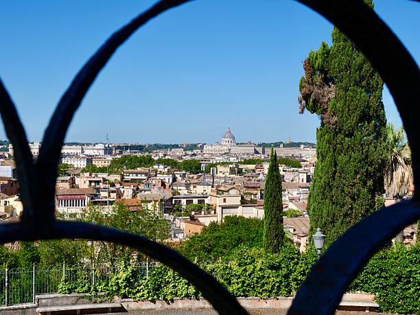 A picturesque panoramic view of the Rome cityscape, showcasing its traditional terracotta rooftops and numerous historical domes and spires. The scene captures the timeless beauty and rich history of the Eternal City.