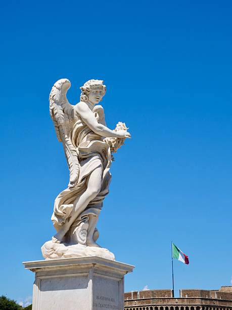 A magnificent marble angel statue stands on the Ponte Sant'Angelo in Rome, with a vibrant Italian flag and the historic Castel Sant'Angelo visible in the background against a clear blue sky.