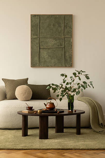 istock Cozy modern sofa with olive and beige pillows, round cushion  and coffee table with teapot, eucalyptus in a vase and decorative tray. 2233501805