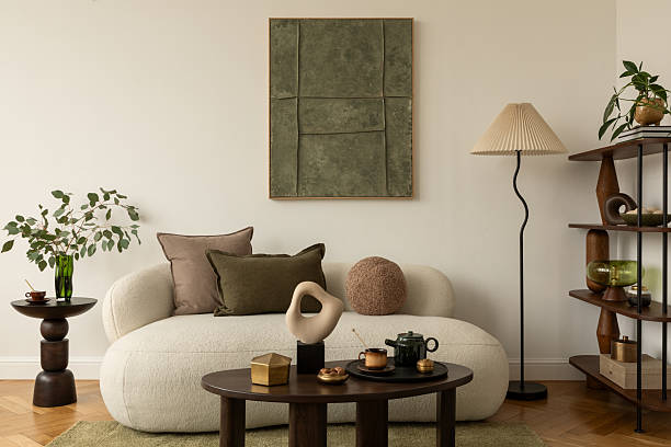 istock Contemporary living room with white sofa, decorative pillows, sculptural objects, coffee table with tea set, and wall art in green tones. Mock up paintings. 2233501825