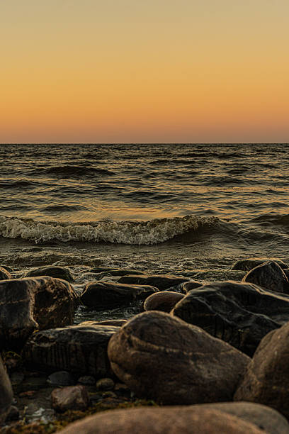 istock Rocky seashore with waves at sunset 2233502777