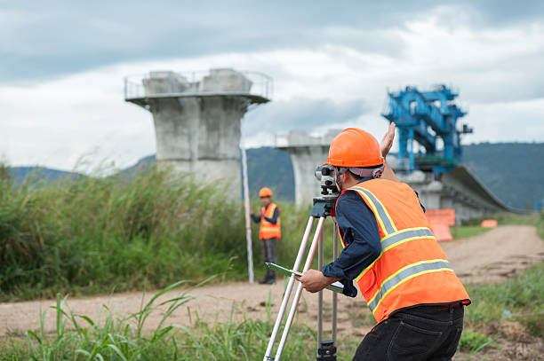 istock Survey technical checking level of site construction with leveling camera digital.  Survey Team Using Leveling Instrument at Elevated High-Speed Railway Construction Site 2233502868