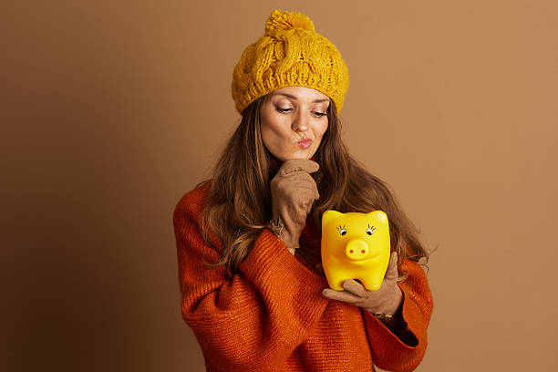 Contemplative Woman Pondering Piggy Bank Savings stock photo