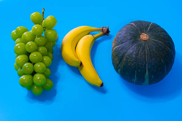 Grape, banana, pumpkin on the blue background. High quality photo