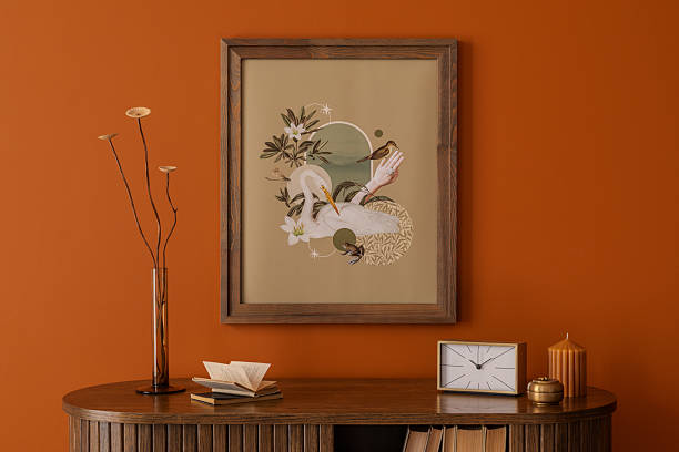 istock Framed mock up poster  artwork styled with natural tones, wooden textures and modern accessories on a orange wall. Template. 2233506543