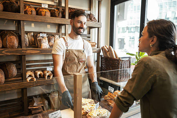 istock Cheerful bakery seller serving fresh pastry to customer 2233506833