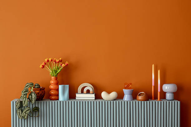 istock Minimalist orange wall with sideboard decorated with tulips, candles and contemporary decorative objects. Copy space. 2233507672