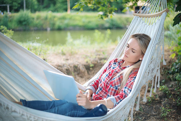 istock Freelancer working from a hammock near a lake 2233511079