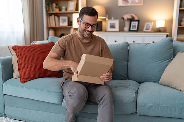 istock Happy customer opening a package at home 2233511081