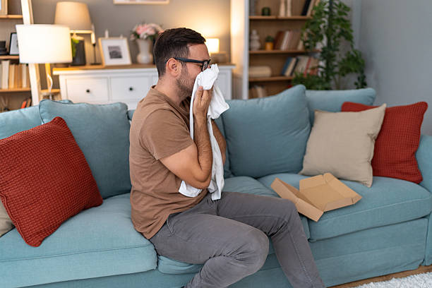 istock Man smelling clothes of someone he misses while sitting on sofa 2233511121