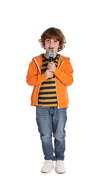 istock Little boy with microphone singing on white background 2233512655