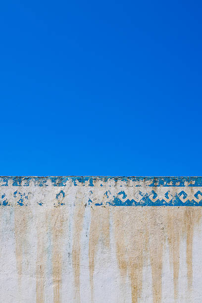 istock Weathered blue and white wall with painted design outdoors 2233514030