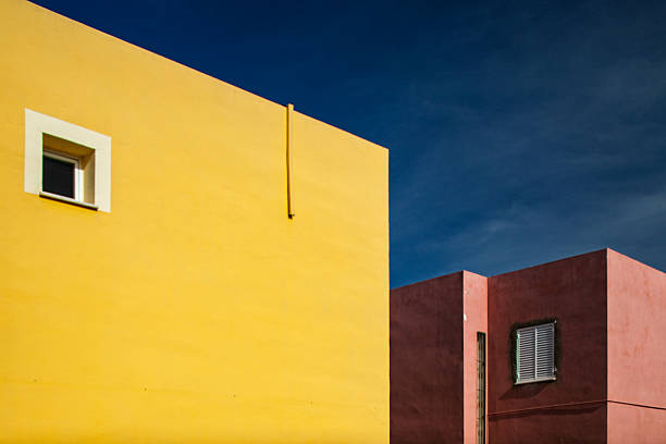 Abstract composition featuring yellow and terracotta façades against a striking blue sky highlights the architectural beauty of Seville.