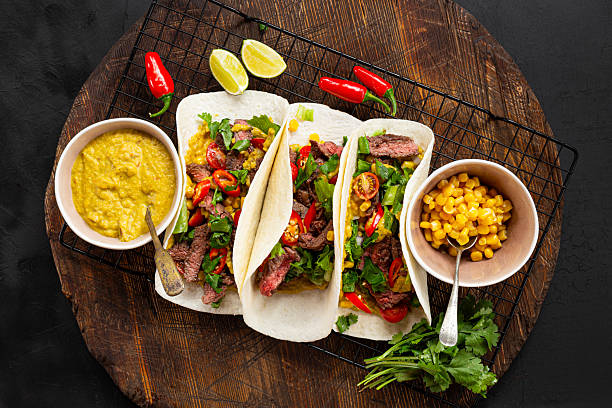 istock Mexican tacos with beef, tomatoes, vegetables, chilli and onions top view 2233519815