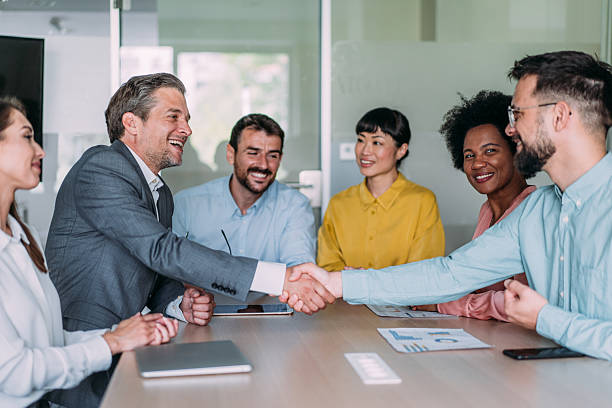 istock Businessmen shaking hands across the table. 2233519871
